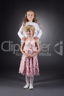Image of beautiful little sisters posing in studio