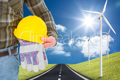 Composite image of manual worker holding helmet and gloves