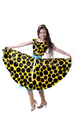 Curly-haired fashionista posing in polka dot dress