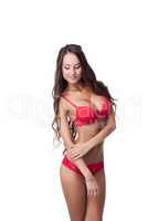 Flirtatious tanned model posing in red lingerie