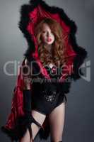 Sexy red-haired girl posing in devil costume