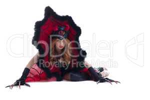 Wary red-haired girl posing in devil costume