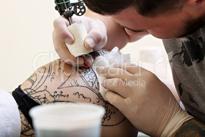 Image of master creates tattoo, close-up