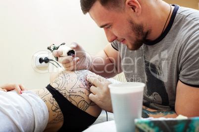 Studio shot of bearded tattooist at work