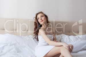 Dreamy woman posing in hotel bedroom
