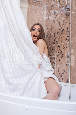 Image of pretty woman hiding behind shower curtain