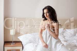 Image of topless woman posing in hotel bedroom