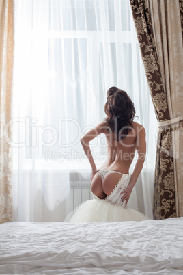 Rear view of sexy naked bride in hotel room