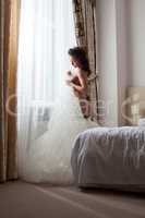Sexy bride undressing in hotel room