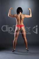Rear view of tanned female dancer shows biceps
