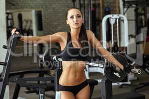 Shapely muscular girl posing in gym