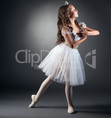 Side view of adorable little ballerina posing
