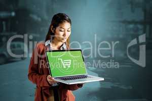 Composite image of smiling businesswoman showing a laptop