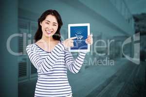 Composite image of cheerful woman pointing at tablet computer