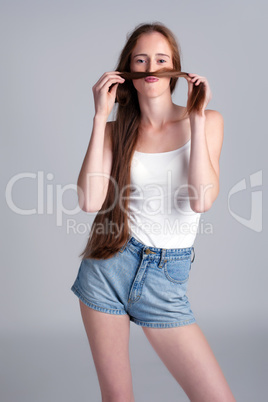 Girl fooling around making mustache of her hair