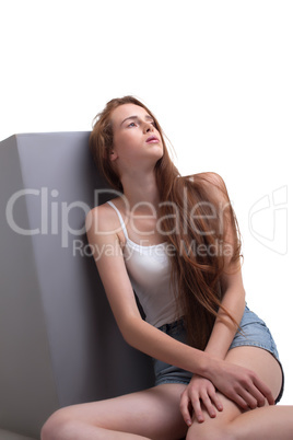 Sad long-haired girl posing in studio