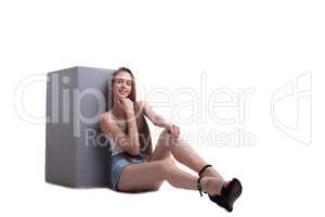 Smiling young girl sits leaning against cube