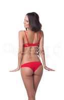 Rear view of smiling slim model in red lingerie