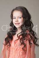 Portrait of adorable girl posing in coral dress