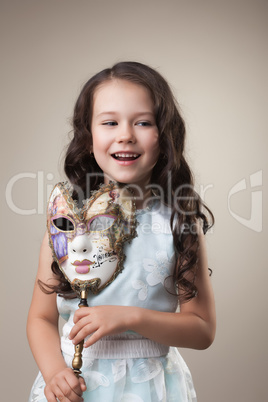 Cheerful little girl posing with carnival mask