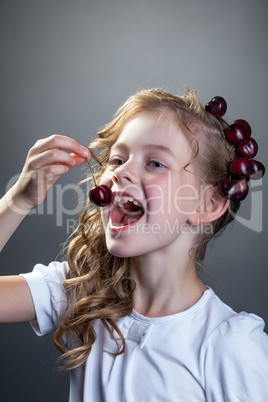 Image of cute little girl wants to taste cherry