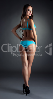 Smiling skinny model posing in blue lingerie