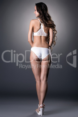 Rear view of underwear model posing on gray backdrop