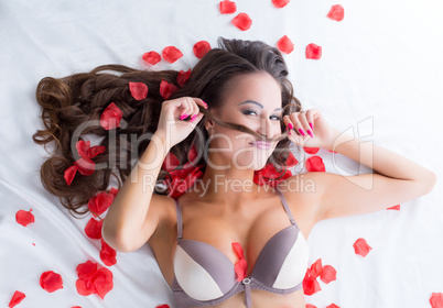 Portrait of funny lingerie model posing in bed