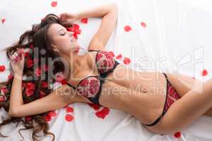 Gorgeous underwear model posing with rose petals