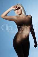 Naked blonde posing squinting in bright light