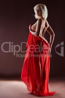 Curvy blonde posing naked with red silk cloth
