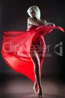 Graceful blonde dancing naked with red cloth