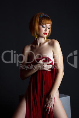 Naked red-haired model posing with velvet cloth