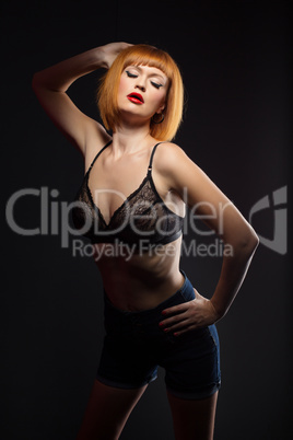 Languorous red-haired woman posing at camera
