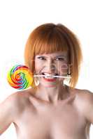 Funny redhead woman squeezes lollipop by teeth