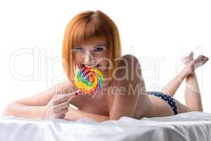 Playful pin-up girl posing with colorful lollipop