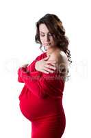 Elegant pregnant brunette posing in red dress