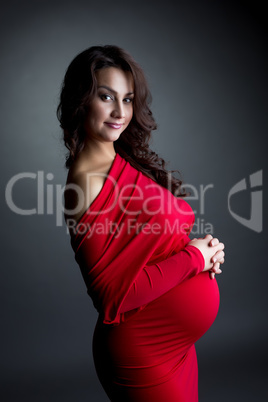 Smiling expectant mother posing at camera