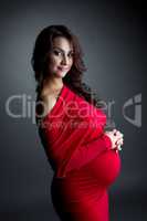 Smiling expectant mother posing at camera