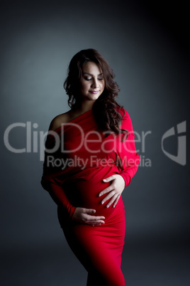 Elegant expectant mother posing in studio