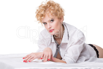 Portrait of beautiful blonde woman lying on bed