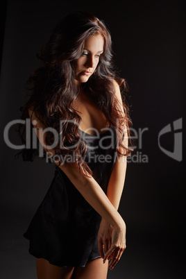 Beautiful tanned girl dressed in black negligee
