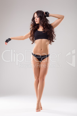 Slender female athlete posing in studio