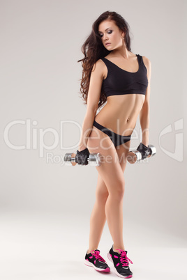 Image of sexy sportswoman posing with dumbbells
