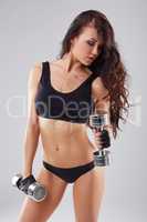 Pretty athletic woman exercising with dumbbells
