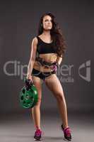 Beautiful female athlete posing with weight disc