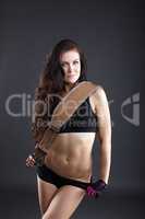 Portrait of cute sporty woman posing with belt