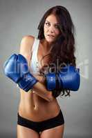 Sexy tanned female boxer posing at camera