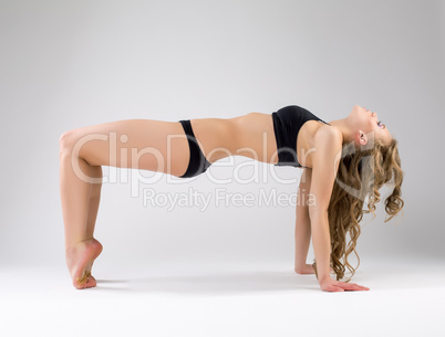 Flexible pilates trainer exercising in studio