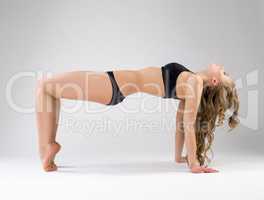 Flexible pilates trainer exercising in studio